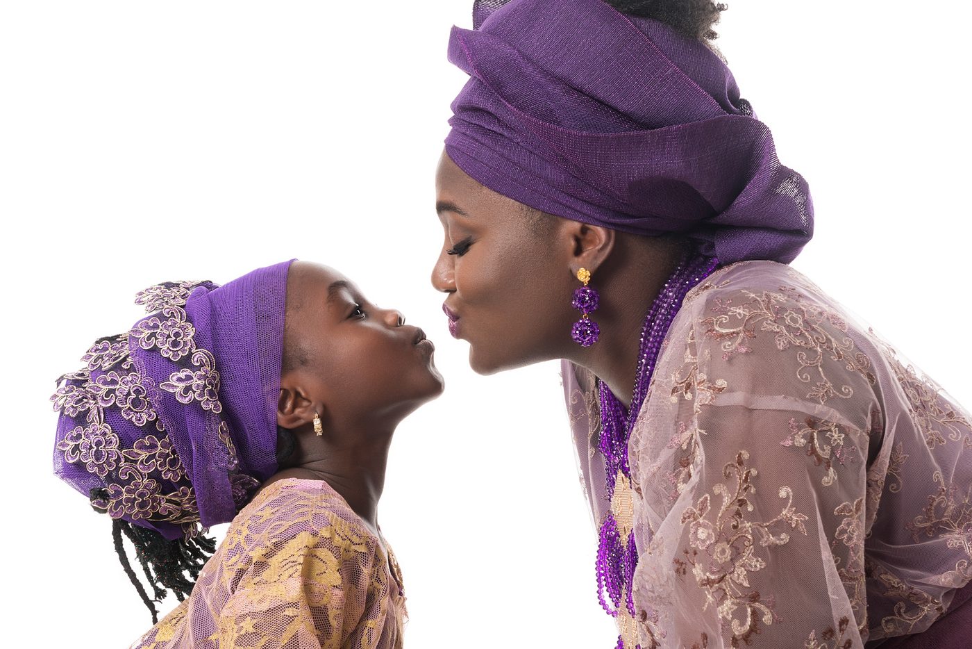 A mother and daughter in matching purple traditional Nigerian attire